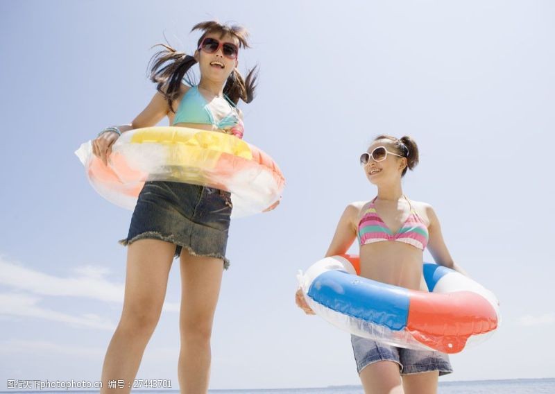 海滩上的美女沙滩上戴太阳镜套游泳圈的美少女图片