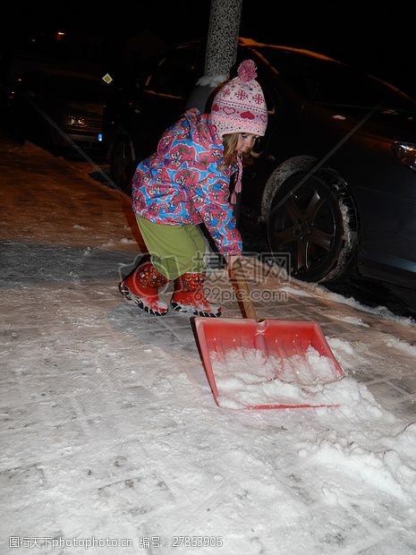 帮忙一个小女孩拿着铲子在铲雪