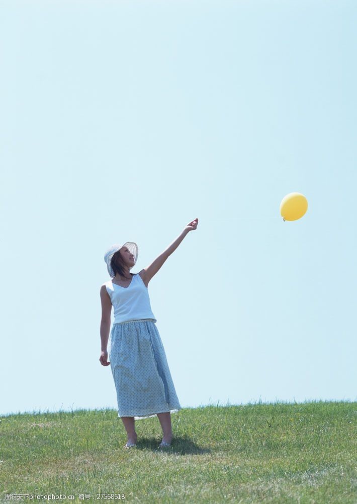假日休闲女性草地上玩气球的美女图片