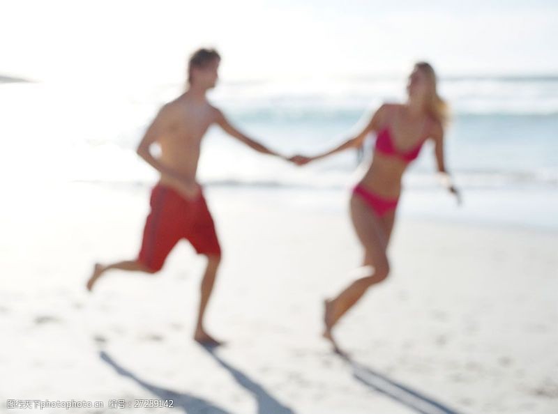 海滩上的美女手牵手走在沙滩上的情侣图片