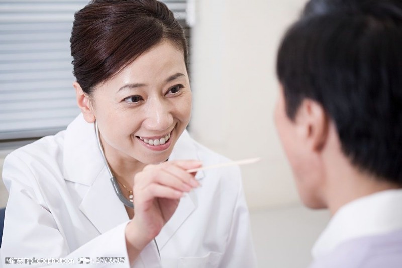 亲切笑容正在为病人检查的女性医生图片