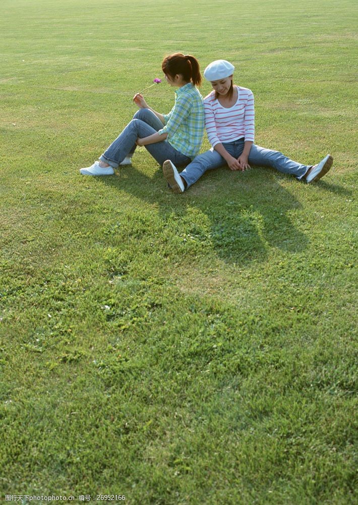 假日休闲女性坐在草地上的两个美女图片