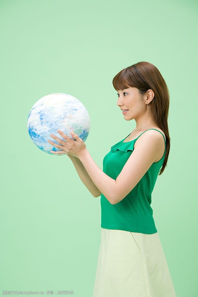 绿色环保背景捧着球看的办公女人图片