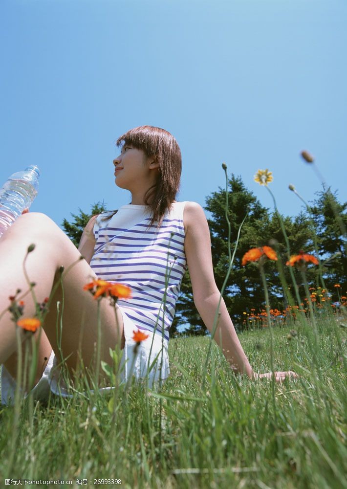 假日休闲女性坐在草地上喝水的美女图片