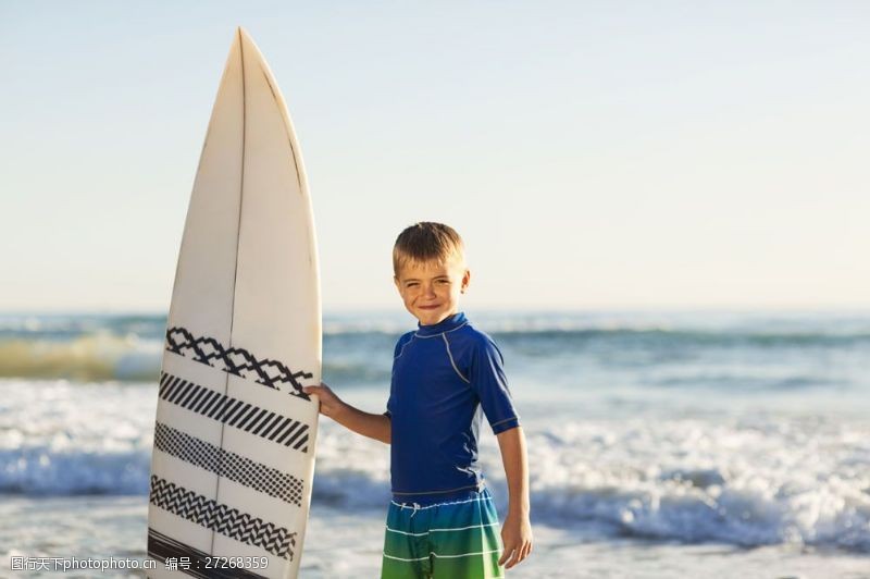 扶着冲浪板微笑的男孩图片
