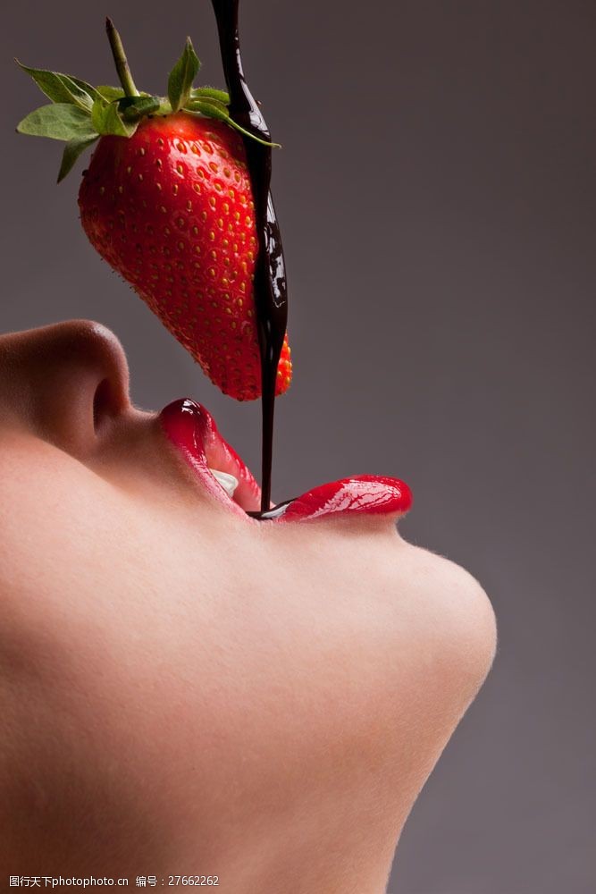 张嘴吃草莓巧克力的女孩特写图片