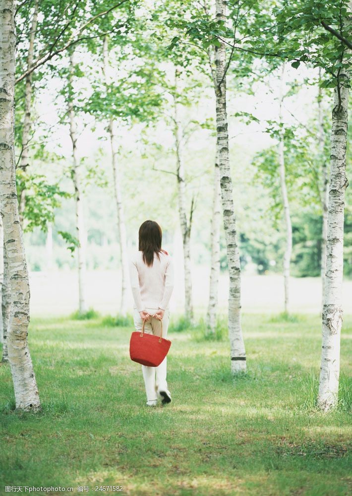 假日休闲女性在树丛中行走的女人图片