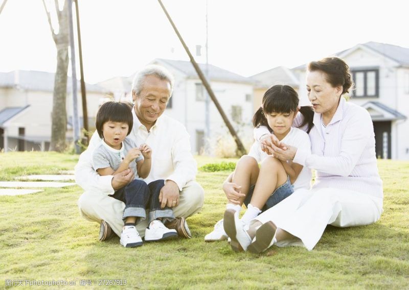 家庭成员坐在草地上的祖孙四人图片