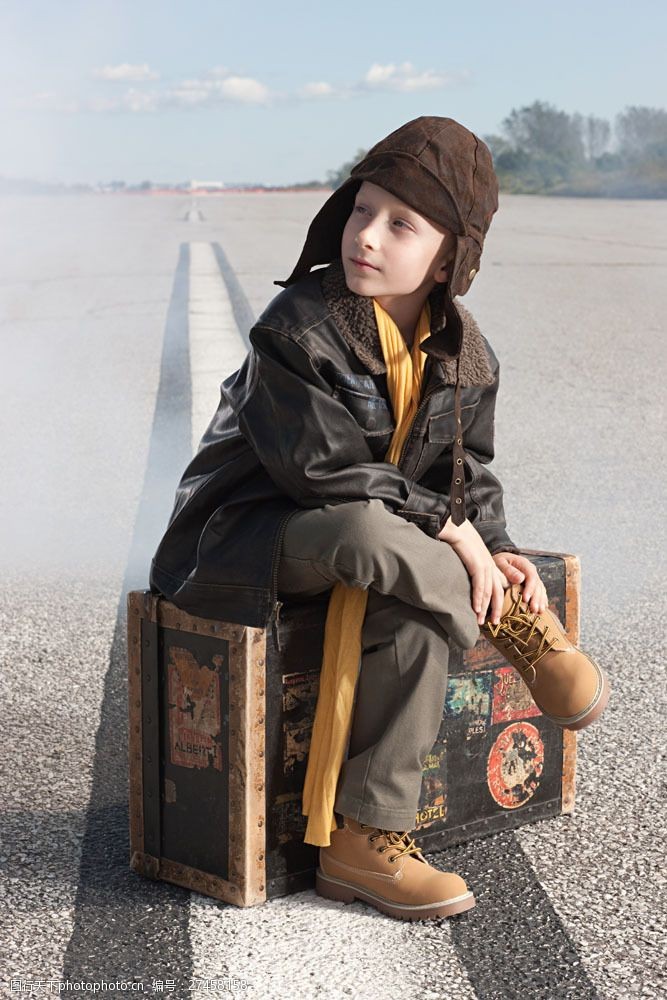 坐驾戴帽子男孩坐着行李箱上的男孩图片