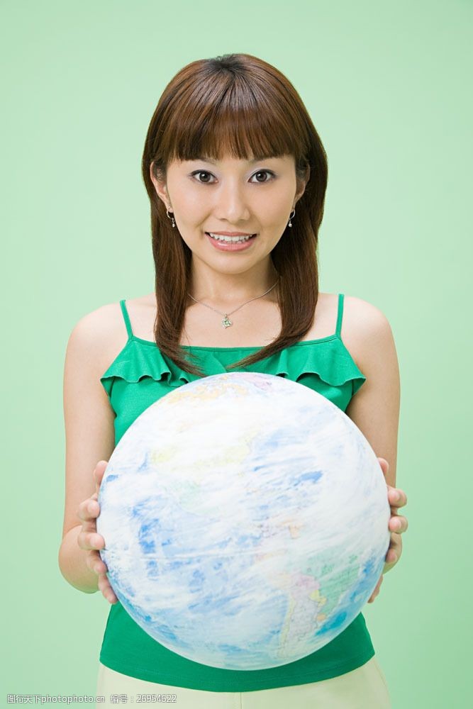 绿色环保背景手捧球体的开心女人图片
