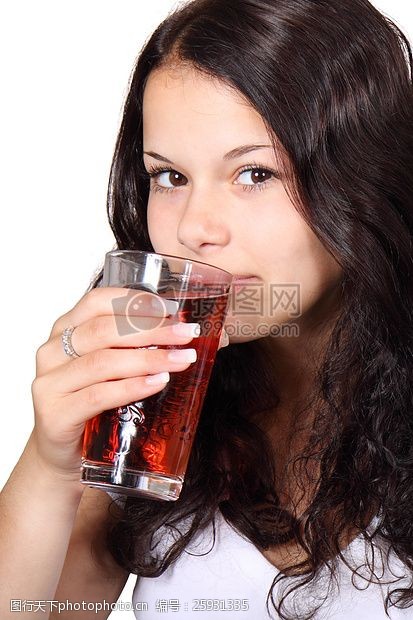 healthy女性在白色V领连衣裙上的水杯喝红饮料