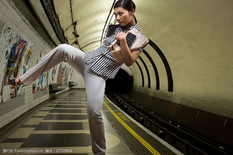 白领踢腿在地铁站台踢腿运动的时尚美女图片