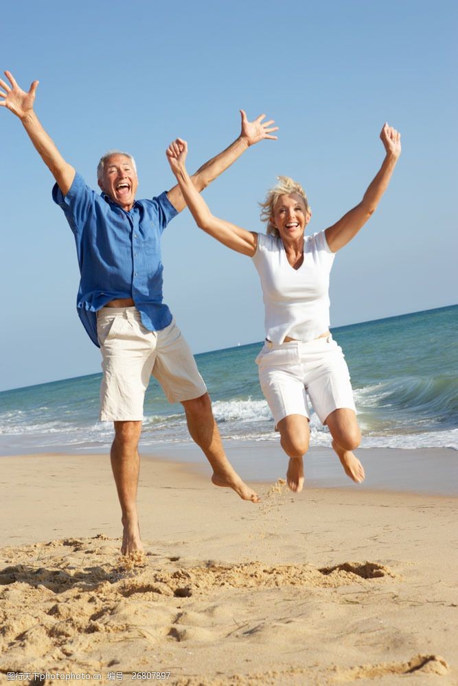 晚年生活沙滩上的跳跃的老人夫妇图片