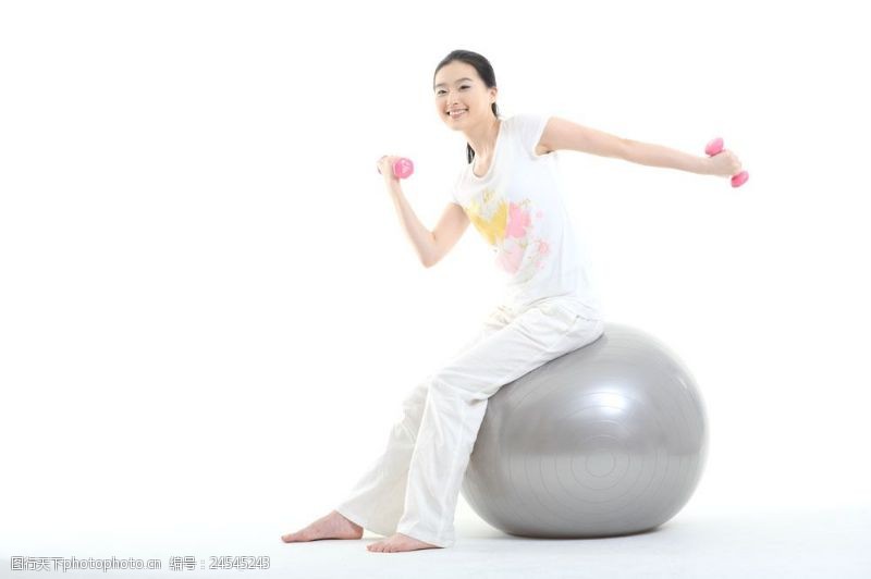 瑜伽造型坐在健身球上做运动的少女图片图片