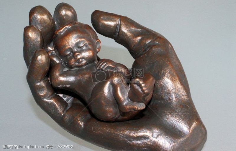 金属的手手掌中的婴儿雕塑