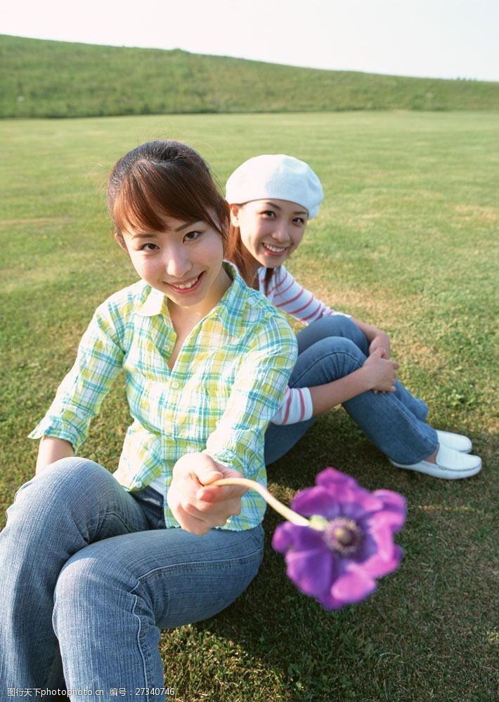 假日休闲女性坐在草地上的两个休闲美女图片