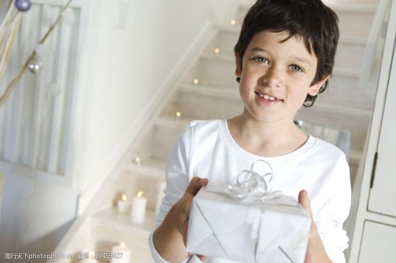 圣诞白蜡烛捧着礼物的小男孩图片
