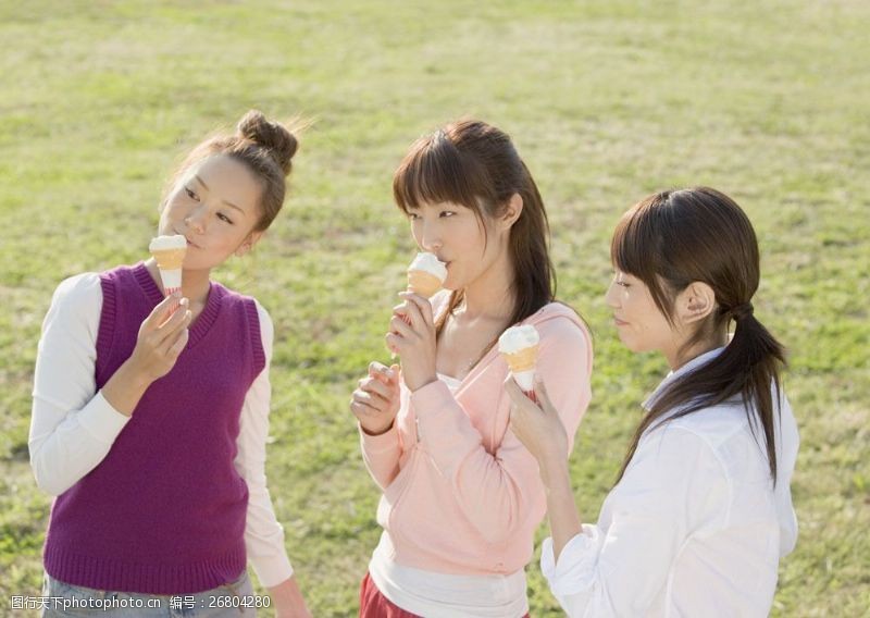 三姐妹草地上吃冷饮的少女图片