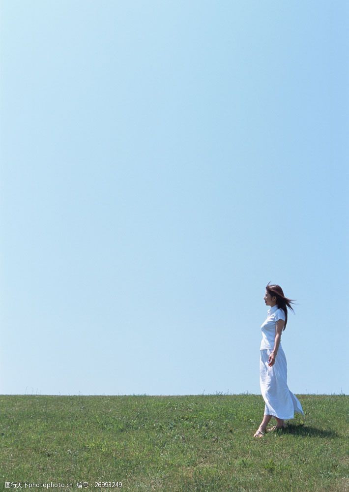 假日休闲女性行走在草地上的女人图片