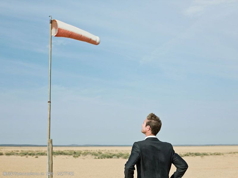 气候站在沙漠中仰望风口袋的外国商业男人图片