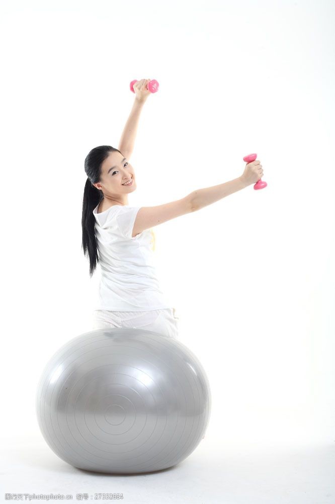健康美女坐在健身球上举哑铃的运动少女图片图片