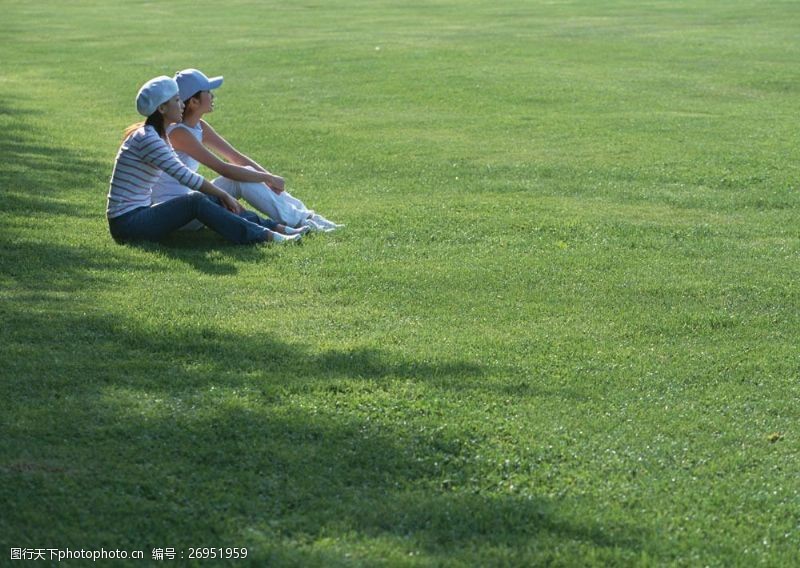 假日休闲女性坐在草地上的两个美女图片