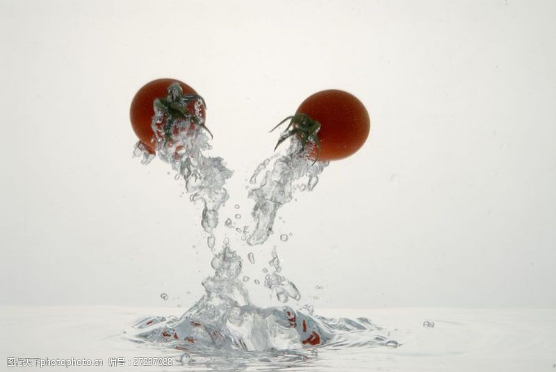 液体从水里蹦出的蕃茄特写图片