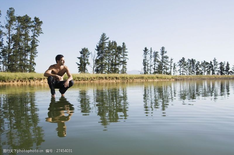 男人上半身蹲在水面上看着远处的男人图片