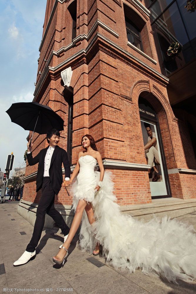 情侣模特打雨伞的新娘新郎图片