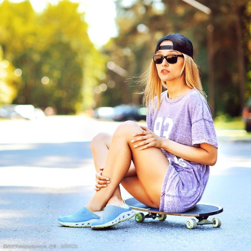 年轻坐在滑板上的时尚女孩图片