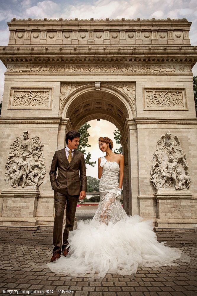 夫妻凯旋门前拍婚纱照的男女图片
