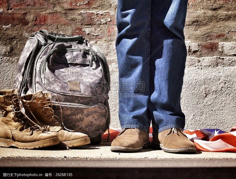 军靴人蓝色牛仔裤和棕色麂皮鞋站在附近迷彩背包棕色登山鞋和美国国旗在地板上