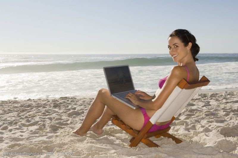 海滩上的美女沙滩上玩笔记本电脑的美女图片