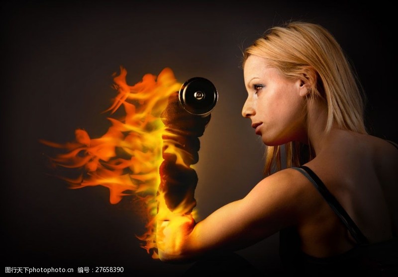 健身的美女举杠铃着火的手臂图片